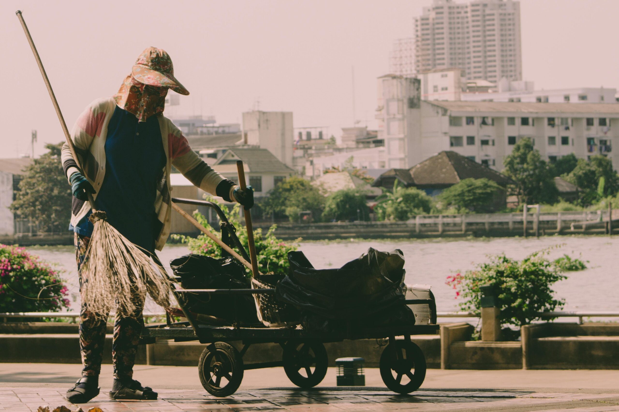Worker sweeping beside a cart