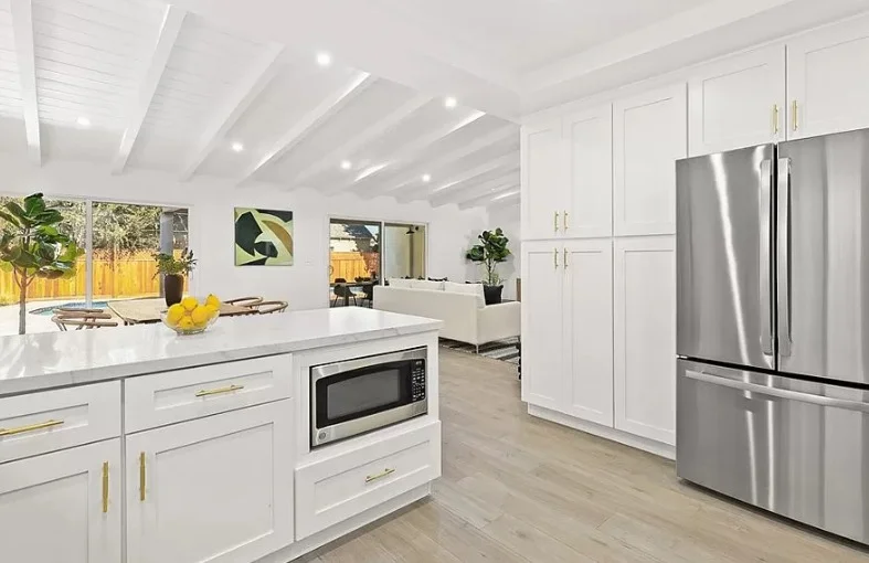 White kitchen with stainless steel refrigerator