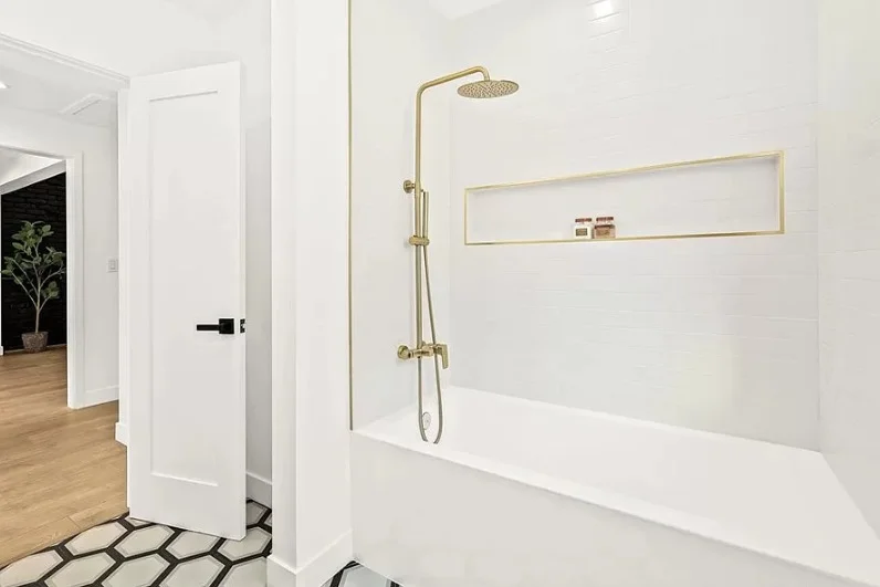 Bathtub with brass shower fixtures