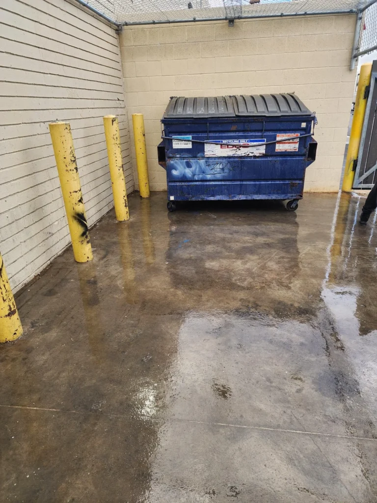 Clean pavement beside a dumpster