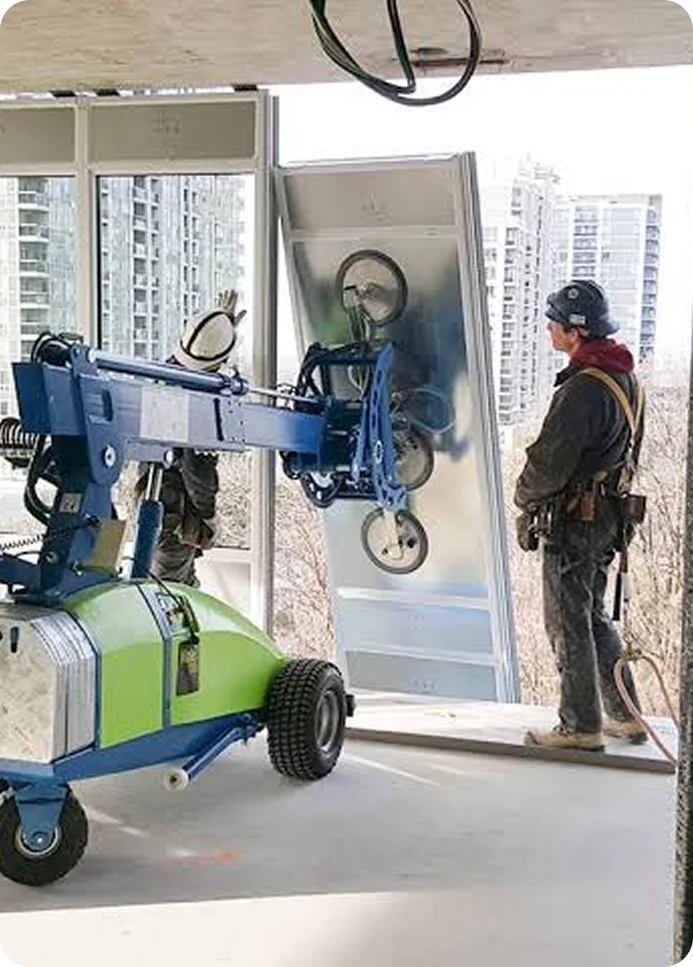 Workers positioning glass with lifting equipment