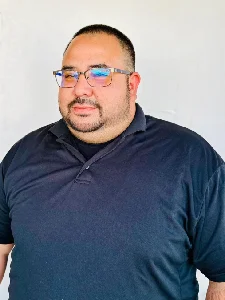 Man wearing glasses and a navy polo